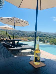 a bottle of beer sitting on a table next to a pool at Estudio a 5 minutos de Sayulita -Parota 1 in San Ignacio