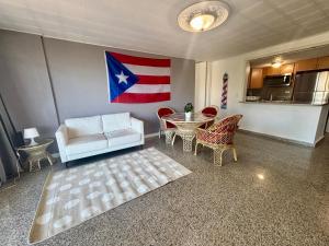 a living room with an american flag on the wall at Oceanfront Isla Verde 2B 2B Apartment Paradise Getaway in San Juan +20 photos