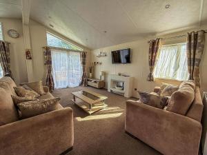 a living room with two couches and a tv at Luxury 6 Berth Lodge With Wifi At Broadland Sands In Suffolk Ref 20011Cv in Hopton on Sea