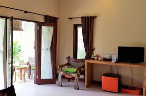 a living room with a television and a desk with a chair at Casa De Amed in Amed