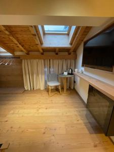 a room with a table and a chair and a television at Naturae Lodge Wellness & Spa in Alleghe