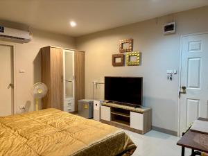 a bedroom with a bed and a flat screen tv at Modicoff Hotel in Sathani Ban Chim Phali