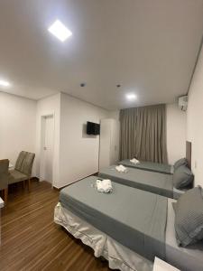 a hotel room with two beds and a television at Stunt Residence Hotel in Sao Paulo
