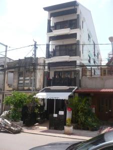a white building with a white awning in front of it at FAA Apartment in Vientiane