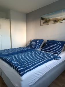 a bed with blue and white pillows on it at Ostseemeerchen in Zingst
