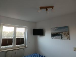 a bedroom with a bed and a tv and a window at Ostseemeerchen in Zingst