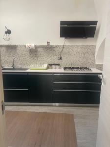 a black kitchen with a sink and a stove at B&B Carafa in Bovino