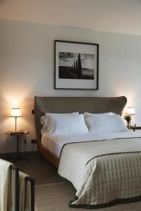 a bedroom with a bed and a picture on the wall at La Serena Forte dei Marmi, Small Luxury Hotels of the World in Forte dei Marmi