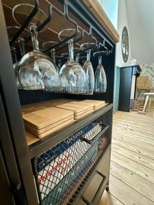 a kitchen with wine glasses and wooden floors at Maison de ville - 6 personnes - proche plage in Saint-Pair-sur-Mer