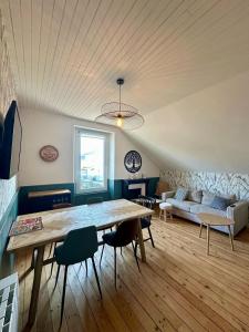 a living room with a large wooden table and chairs at Maison de ville - 6 personnes - proche plage in Saint-Pair-sur-Mer +20 photos