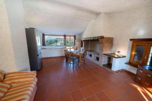 un soggiorno con divano, tavolo e camino di Casa Ghirlanda con Piscina e Campo da Tennis a Lazise