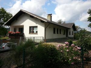 a white house with flowers in front of it at Kleine Wohnung am Radweg in Witzenhausen