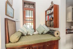 a room with a bench with pillows and a window at House by The Sea Hikka in Hikkaduwa