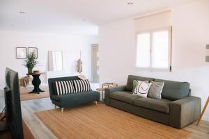 ein Wohnzimmer mit einer Couch und einem Sessel in der Unterkunft Just Like Home - Casa Rosa in Padornelo