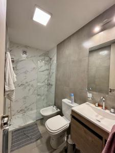 een badkamer met toilet, wastafel en douche bij Departamentos Céntricos Exclusivos in Villa Carlos Paz