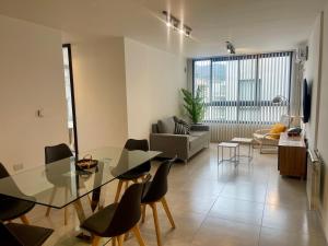 een woonkamer met een glazen tafel en stoelen bij Departamentos Céntricos Exclusivos in Villa Carlos Paz