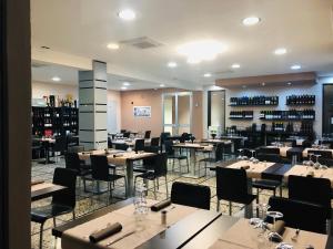 a restaurant with tables and chairs and wine bottles at Hotel Le Nereidi in Cervo