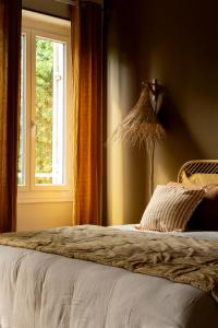 a bedroom with a bed with a window at LE DOMAINE DE FERRAT in Mirambeau