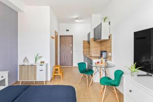 a bedroom with a bed and a table with green chairs at Apartment 42 in Sighişoara