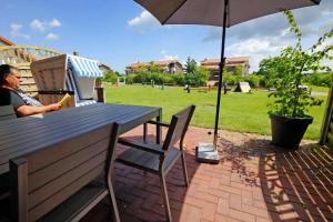 HohenkirchenにあるAppartement In Hohen Wieschendorfの傘下のテーブルに座る男 +5枚の写真