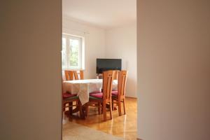 a dining room with a table and chairs and a television at Dolce Mare Apartmani in Pakoštane