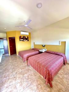 a hotel room with two beds and a ceiling at Hotel la Palapa Mazatlan in Mazatlán