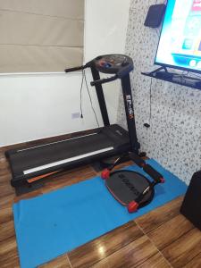 a treadmill sitting on a blue floor next to a tv at Hostel da Rô, Praia Grande in Praia Grande