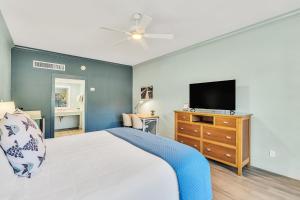 a bedroom with a bed and a television on a dresser at Beachside Inn in Destin