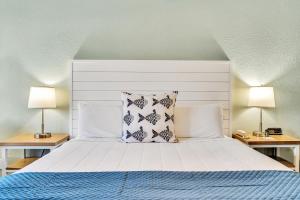 a bedroom with a white bed with two lamps at Beachside Inn in Destin