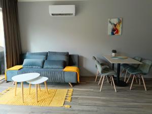 a living room with a blue couch and a table at Domki Szychówka in Szczawina