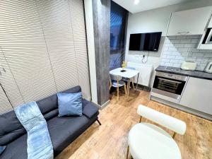 a living room with a couch and a kitchen at Luxury Studio Suite Town Centre Short Stay in Maidstone +13 photos