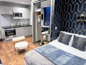 a small bedroom with a bed and a kitchen at Luxury Studio Suite Town Centre Short Stay in Maidstone