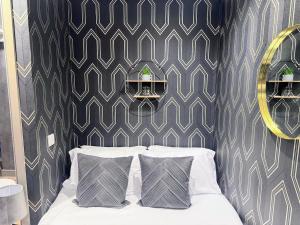 a bedroom with a bed with two pillows and a wall at Luxury Studio Suite Town Centre Short Stay in Maidstone