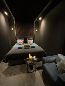 a black room with a bed and a couch at La Chambre Delta in Morlanwelz-Mariemont