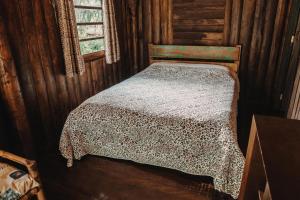 une chambre avec un lit dans une pièce en bois dans l'établissement Chalé Sanga, à Jaraguá do Sul