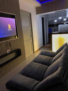 a living room with three couches in front of a tv at The Roam Inn - Fast Wifi Connection in Dipolog