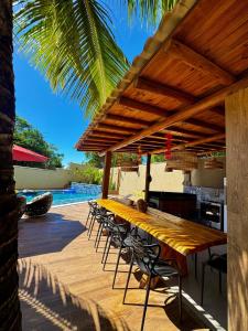 a wooden table and chairs under a wooden roof at Condomínio Ouro vilas in Arraial d'Ajuda