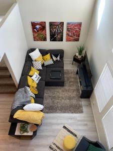 ソルトレイクシティにあるScholar's Loft - Near University of Utah!のリビングルーム(黒いソファ、黄色い枕付)