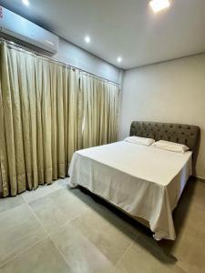 a bedroom with a bed and a large window at Condomínio Ouro vilas in Arraial d'Ajuda +16 photos