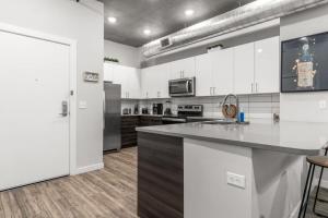 セント・ピーターズバーグにあるModern 2 Bed Getaway Steps from Tropicana Fieldの白いキャビネットとカウンタートップを備えたキッチン
