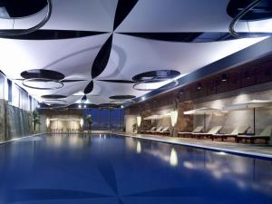 uma piscina num hotel com cadeiras e luzes em voco Changzhou Fudu em Changzhou