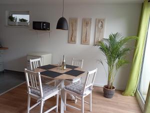 a dining room table with chairs and a potted plant at Engmels Ferienwohnung in Volkertshausen