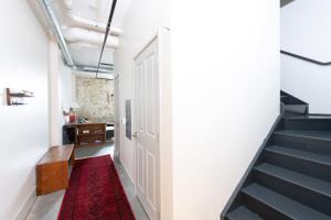 a hallway with stairs and a red rug at Brewery District 2-Story 2BR Apt Near Fiserv with Rooftop, Gym, and Parking in Milwaukee