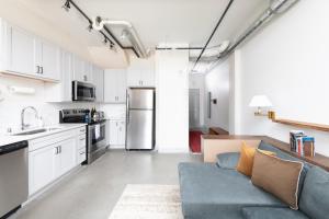 a living room with a blue couch in a kitchen at Brewery District 2-Story 2BR Apt Near Fiserv with Rooftop, Gym, and Parking in Milwaukee