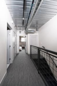 a hallway with a staircase in a room with white walls at Brewery District 2-Story 2BR Apt Near Fiserv with Rooftop, Gym, and Parking in Milwaukee +21 photos