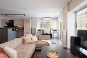 a living room with a couch and a kitchen at Luxe Bliss 2BR, Glyfada in Athens