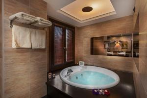 a bathroom with a large tub in a room at Iakovakis Suites & Spa in Koropi