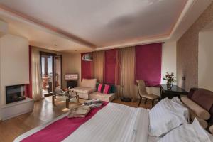 a bedroom with a large bed and a living room at Iakovakis Suites & Spa in Koropi