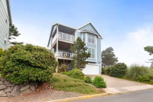 a blue and white house on a street at Blue Marlin, Arcade, Hot Tub, Sleeps 10 in Lincoln City
