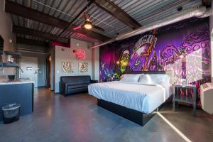 a bedroom with a bed and a graffiticovered wall at Brewhalla Hotel in Fargo